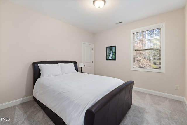 bedroom with light carpet, visible vents, and baseboards