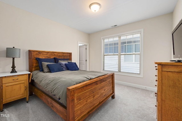 bedroom with light carpet, visible vents, and baseboards