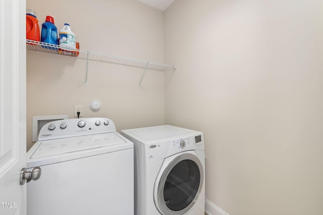 clothes washing area featuring laundry area, baseboards, and independent washer and dryer