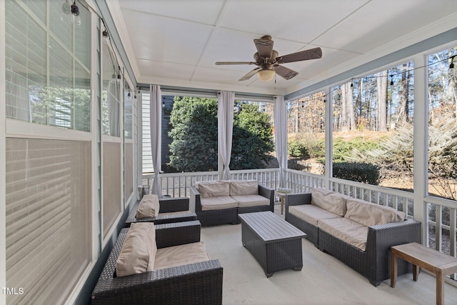 sunroom featuring a ceiling fan, a wealth of natural light, and a paneled ceiling