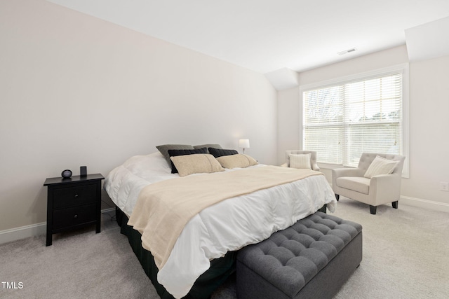 bedroom featuring lofted ceiling, baseboards, visible vents, and light colored carpet