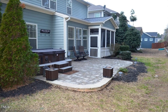 view of patio featuring a sunroom and a hot tub