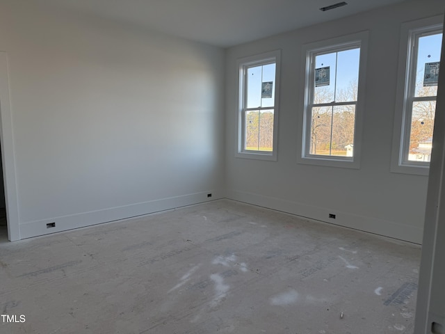 spare room featuring a wealth of natural light and baseboards