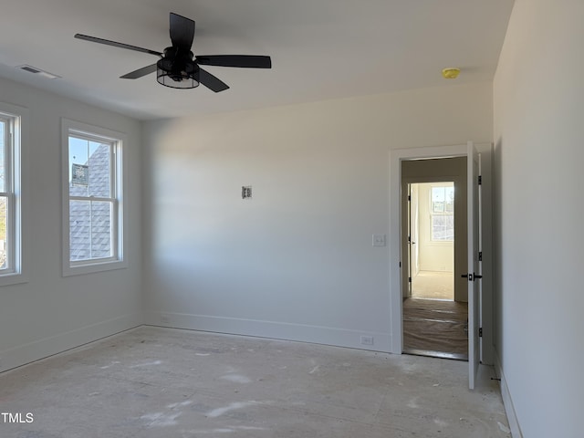 spare room with a ceiling fan, a healthy amount of sunlight, visible vents, and baseboards