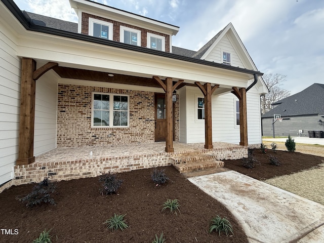 view of front of house with a porch and brick siding