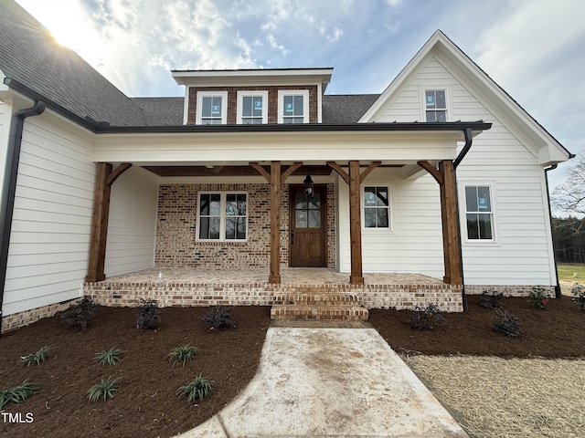 view of front of property featuring a porch and roof with shingles