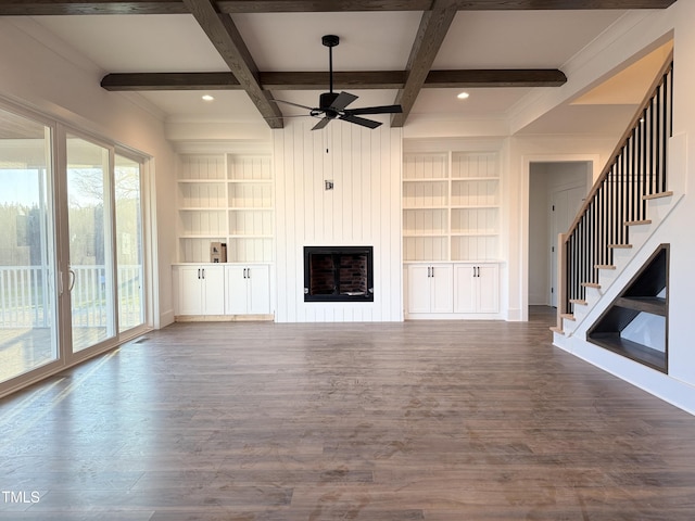 unfurnished living room with a large fireplace, coffered ceiling, dark wood-style floors, and built in features