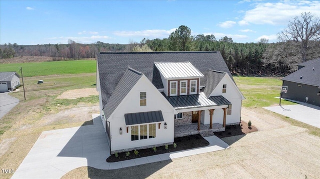 321 Bud Wall Rd, Youngsville, NC 27596 - modern farmhouse with metal roof, a view of trees, a porch, and a standing seam roof