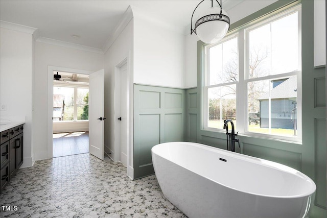 321 Bud Wall Rd, Youngsville, NC 27596 - full bathroom featuring a wainscoted wall, a freestanding bath, ornamental molding, a decorative wall, and a ceiling fan