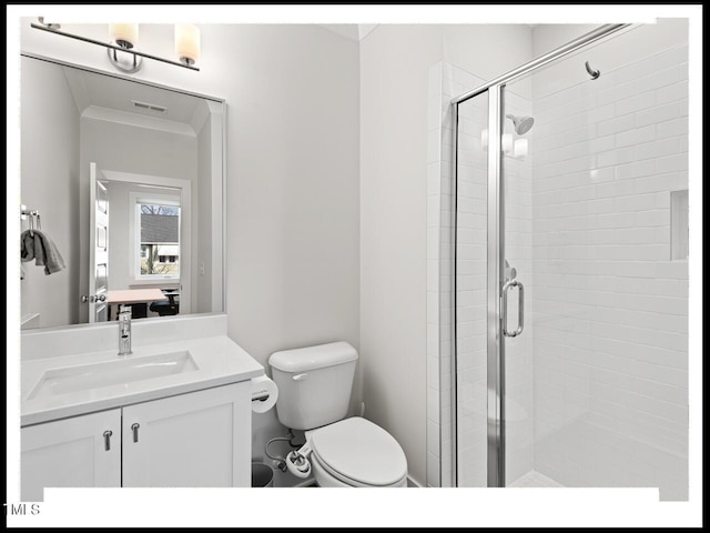 bathroom with ornamental molding, vanity, toilet, and a shower with shower door