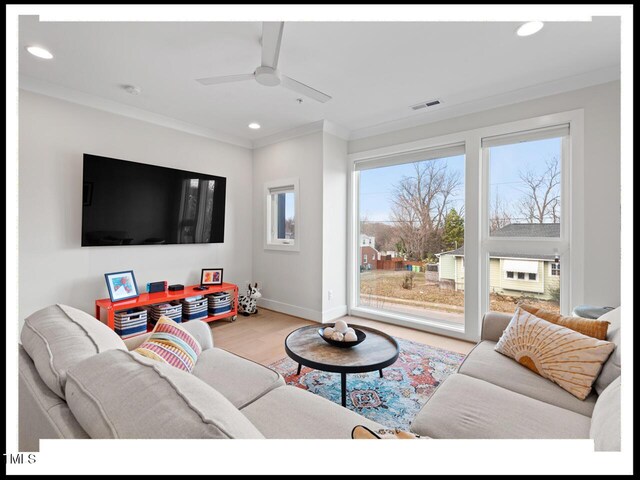 living room featuring crown molding, ceiling fan, and light hardwood / wood-style flooring