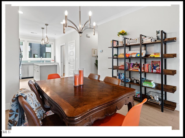 dining area with crown molding, sink, a notable chandelier, and light hardwood / wood-style floors