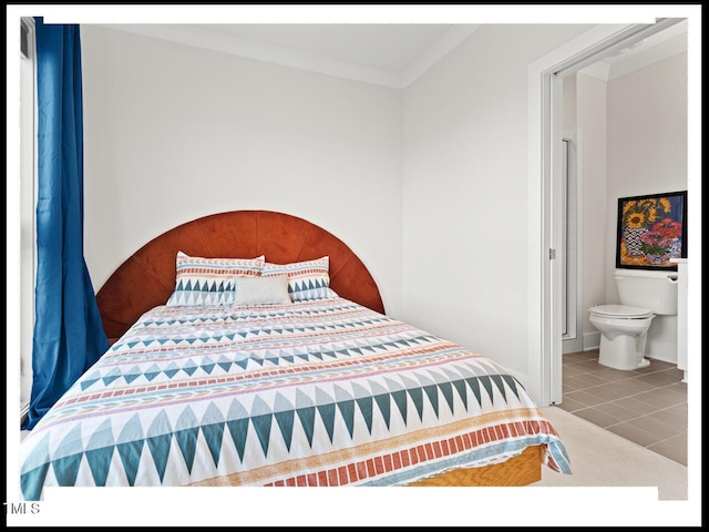 bedroom featuring ornamental molding, tile patterned floors, and ensuite bath