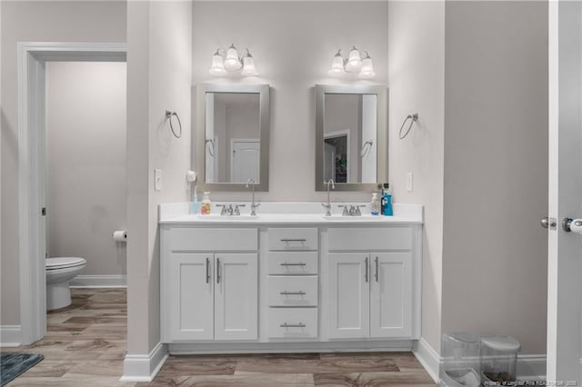 bathroom featuring vanity, hardwood / wood-style floors, and toilet