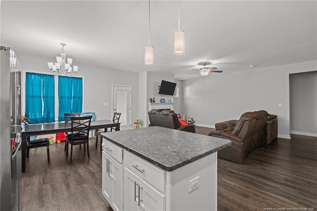 kitchen with a kitchen island, dark hardwood / wood-style floors, white cabinets, and decorative light fixtures