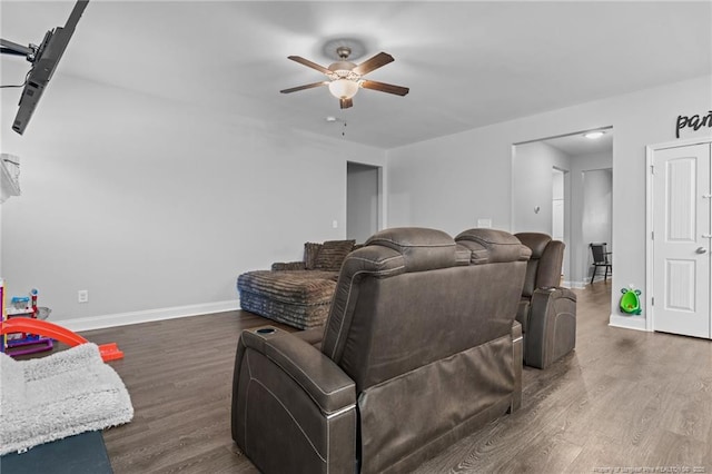 living room featuring dark wood-type flooring and ceiling fan