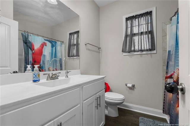 bathroom with vanity, toilet, hardwood / wood-style floors, and a wealth of natural light