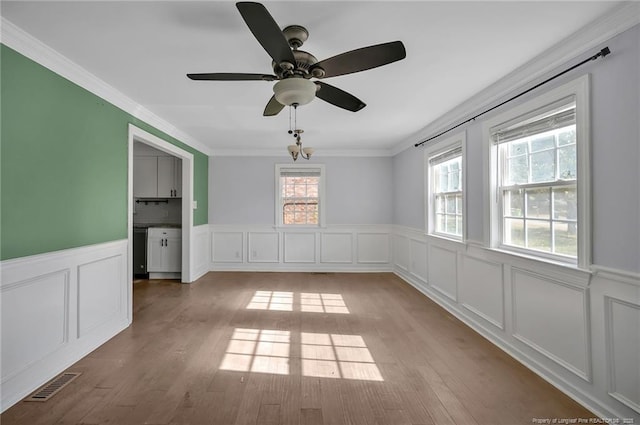 empty room featuring ornamental molding, ceiling fan, and light wood-type flooring