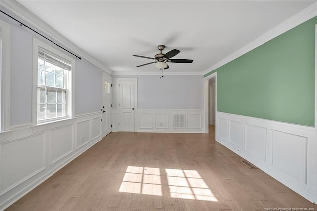 unfurnished room with ceiling fan, ornamental molding, and light hardwood / wood-style floors