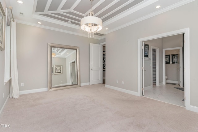 carpeted empty room featuring a notable chandelier and ornamental molding