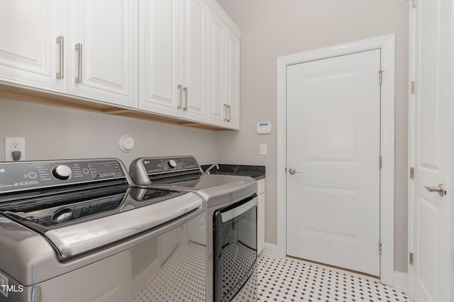 laundry room featuring cabinets and washer and clothes dryer