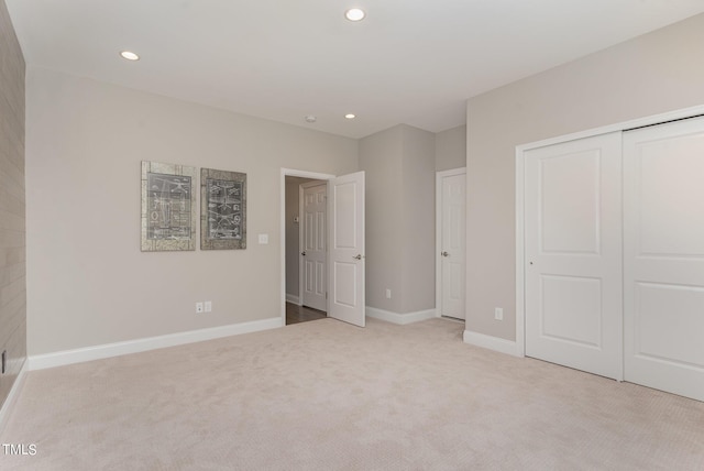 unfurnished bedroom featuring light colored carpet and a closet