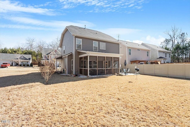 back of house featuring a sunroom, a residential view, and fence