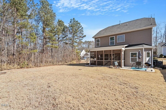 back of house with a sunroom, a patio area, and a lawn