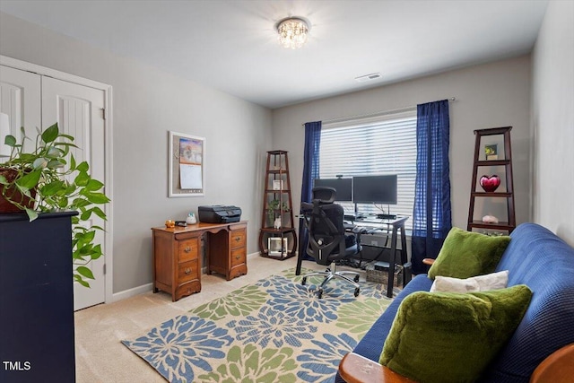 office area featuring baseboards, visible vents, and light colored carpet