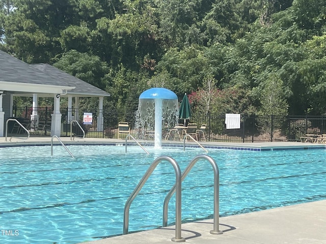 view of swimming pool with fence and a gazebo