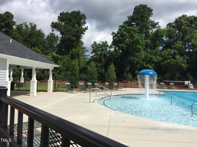 pool with a patio area and fence