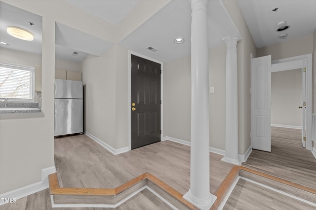 foyer with decorative columns and light wood-type flooring