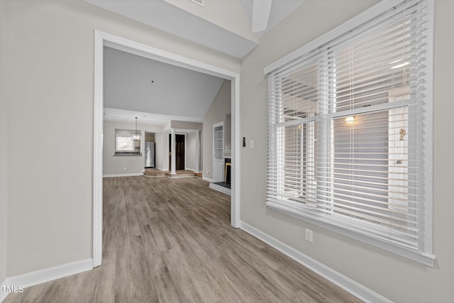 hall featuring hardwood / wood-style flooring and vaulted ceiling