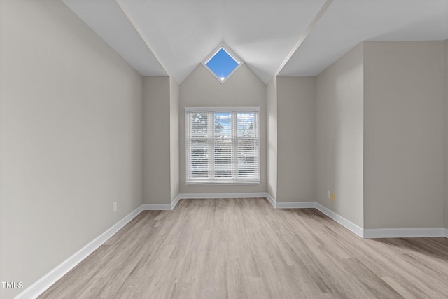 empty room featuring vaulted ceiling and light hardwood / wood-style floors