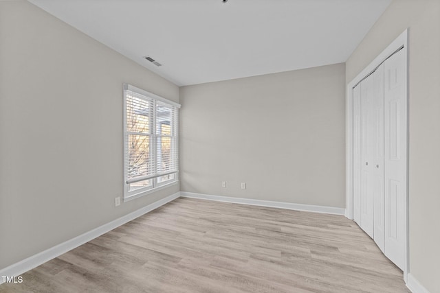 unfurnished bedroom featuring a closet and light hardwood / wood-style flooring