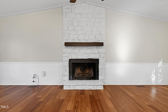 details with ceiling fan, a stone fireplace, and hardwood / wood-style floors