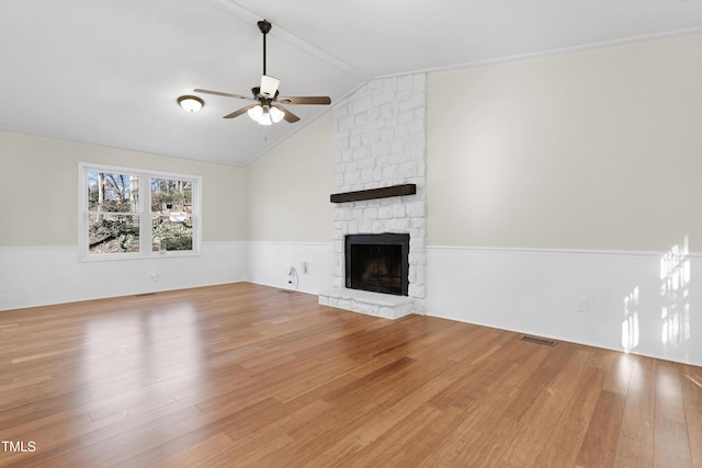 unfurnished living room with hardwood / wood-style flooring, vaulted ceiling, ceiling fan, and a fireplace