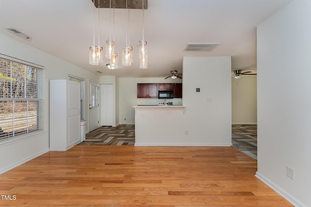 kitchen featuring ceiling fan, pendant lighting, and light hardwood / wood-style floors