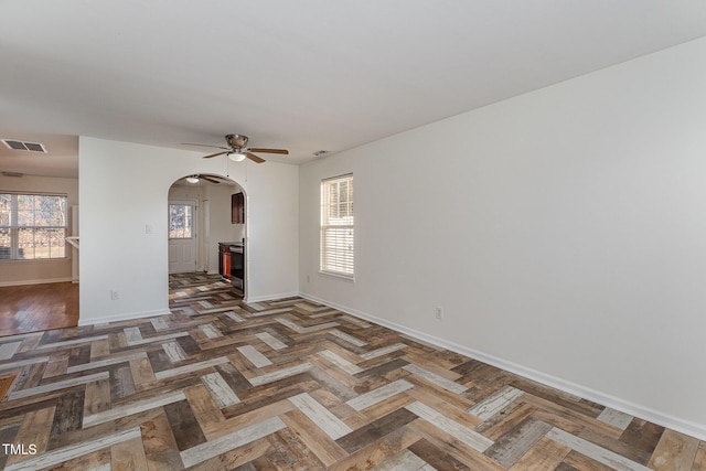 empty room featuring dark parquet flooring and ceiling fan