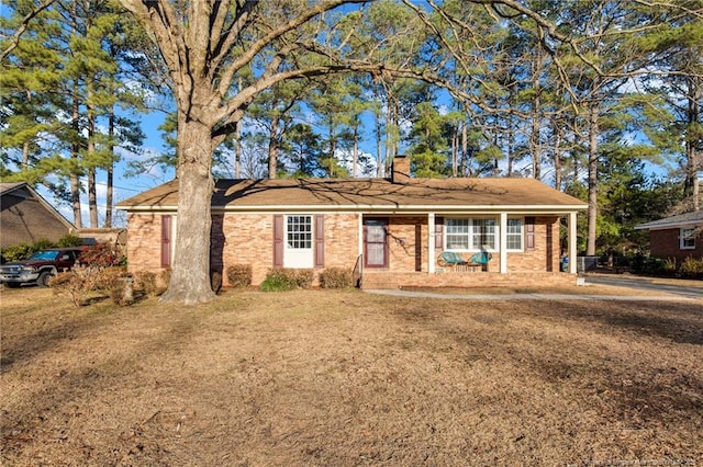 ranch-style house with a porch and a front lawn