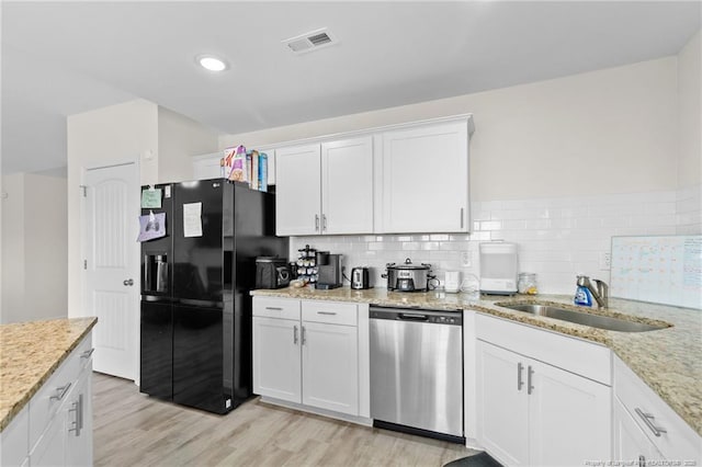 kitchen featuring sink, black fridge, white cabinetry, light wood-type flooring, and dishwasher