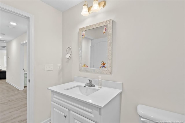 bathroom featuring vanity, hardwood / wood-style flooring, and toilet