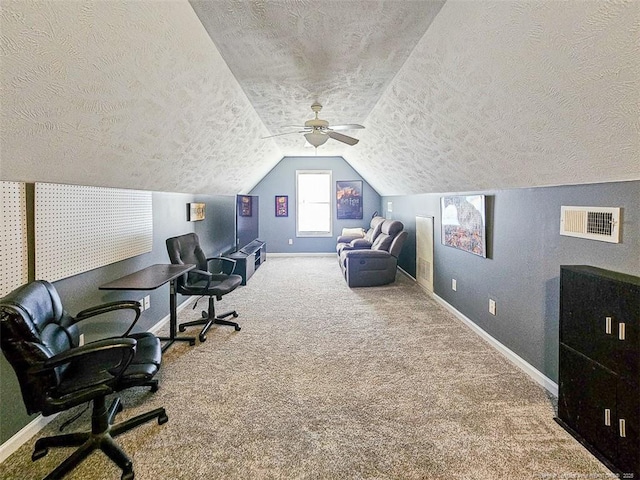 carpeted office with vaulted ceiling and a textured ceiling