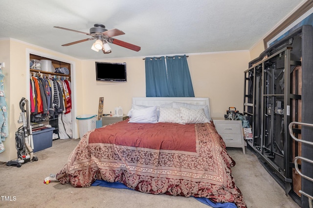 bedroom featuring ceiling fan, ornamental molding, a textured ceiling, light carpet, and a closet