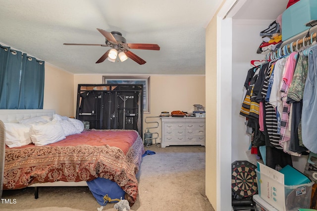 bedroom featuring light carpet, a textured ceiling, and ceiling fan