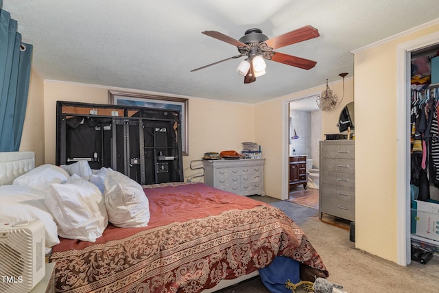 carpeted bedroom featuring crown molding, ceiling fan, connected bathroom, a textured ceiling, and a closet