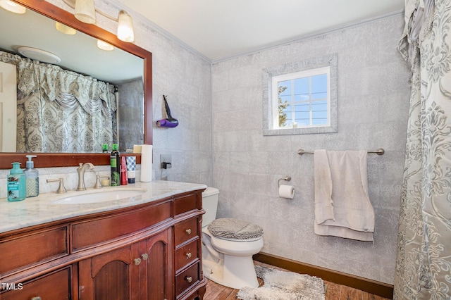 bathroom featuring vanity, wood-type flooring, tile walls, and toilet