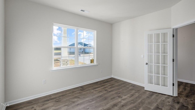 unfurnished room with dark wood-type flooring