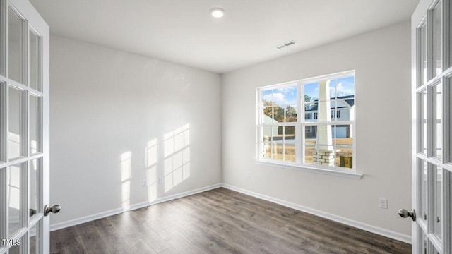 spare room with dark hardwood / wood-style flooring and french doors