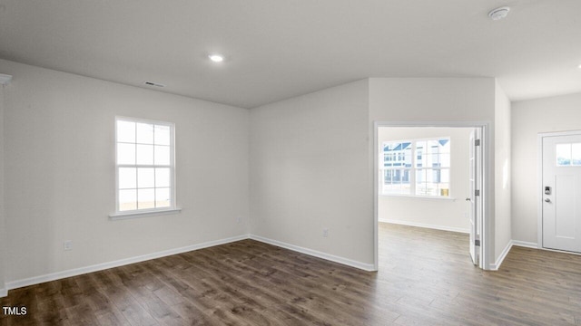 spare room featuring dark hardwood / wood-style floors and a healthy amount of sunlight